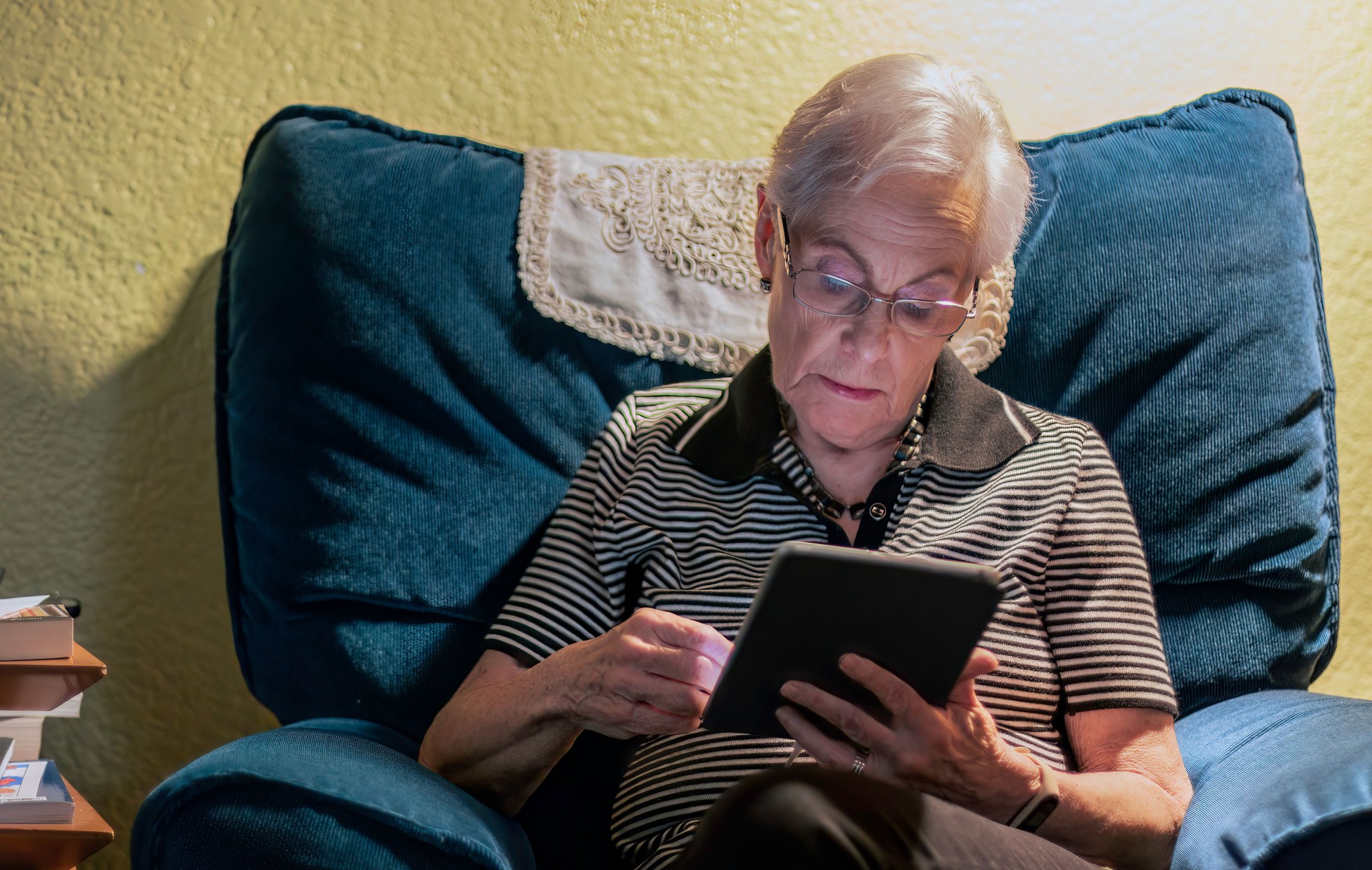 Mujer mayor que usa tableta digital por la noche